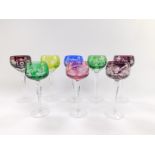 Five continental varicoloured hock glasses, engraved with vines, raised on faceted stems, together