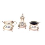 A silver three piece condiment set, with gadrooned rims, raised on three lion's paw and mask feet,