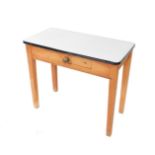 A pine kitchen table, with a white enamel top, above a frieze drawer raised on square legs, 77c, H