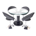 A modern circular glass topped breakfast table, raised on a white metal and faux black leather