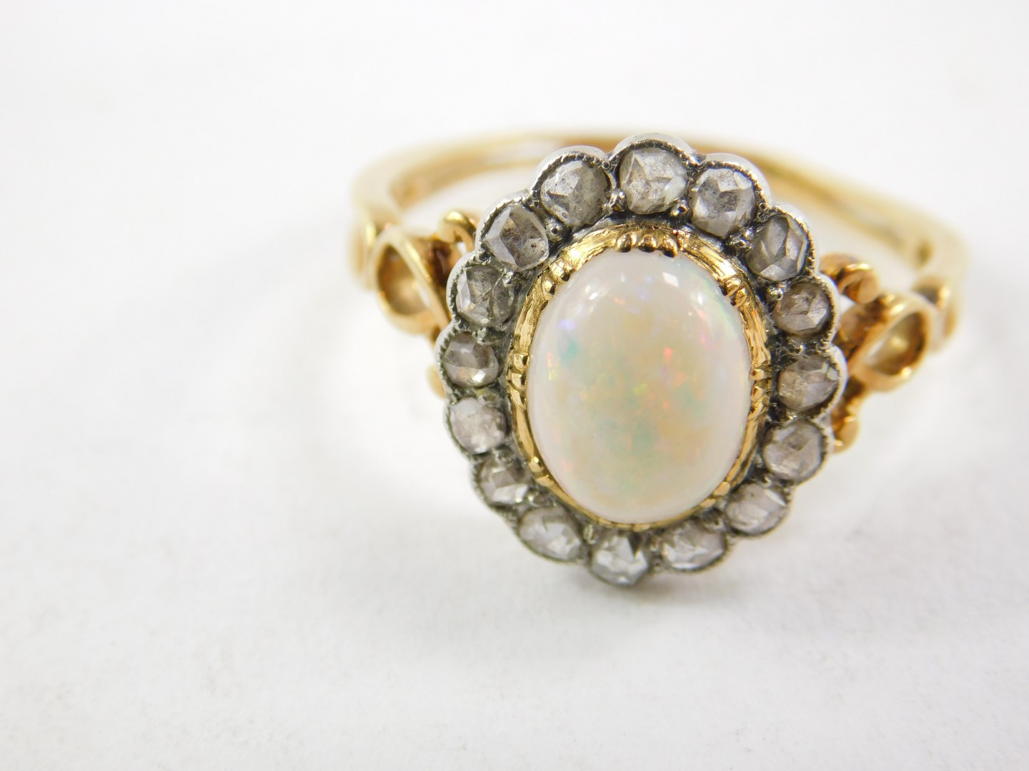 An opal and diamond ring, set in yellow metal, the cabachon opal set in a surround of sixteen old - Image 2 of 3