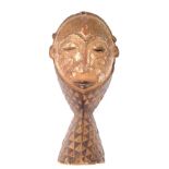 A Punu mask, from The Gabon, the face with carved cheek markings, head covering and geometric carved