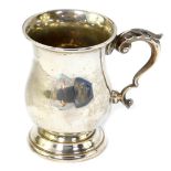 A silver tankard, of baluster form with a double scroll handle and embossed leaf thumb piece,