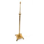 A brass Corinthian column standard lamp, raised on a stepped square base and paw and pad feet, 148cm