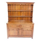 A Georgian style oak dresser, with a two shelf plate rack over two drawers above panelled cupboard