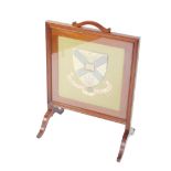 A Victorian mahogany and tapestry fire screen, decorated with a Coat of Arms and motto, raised on