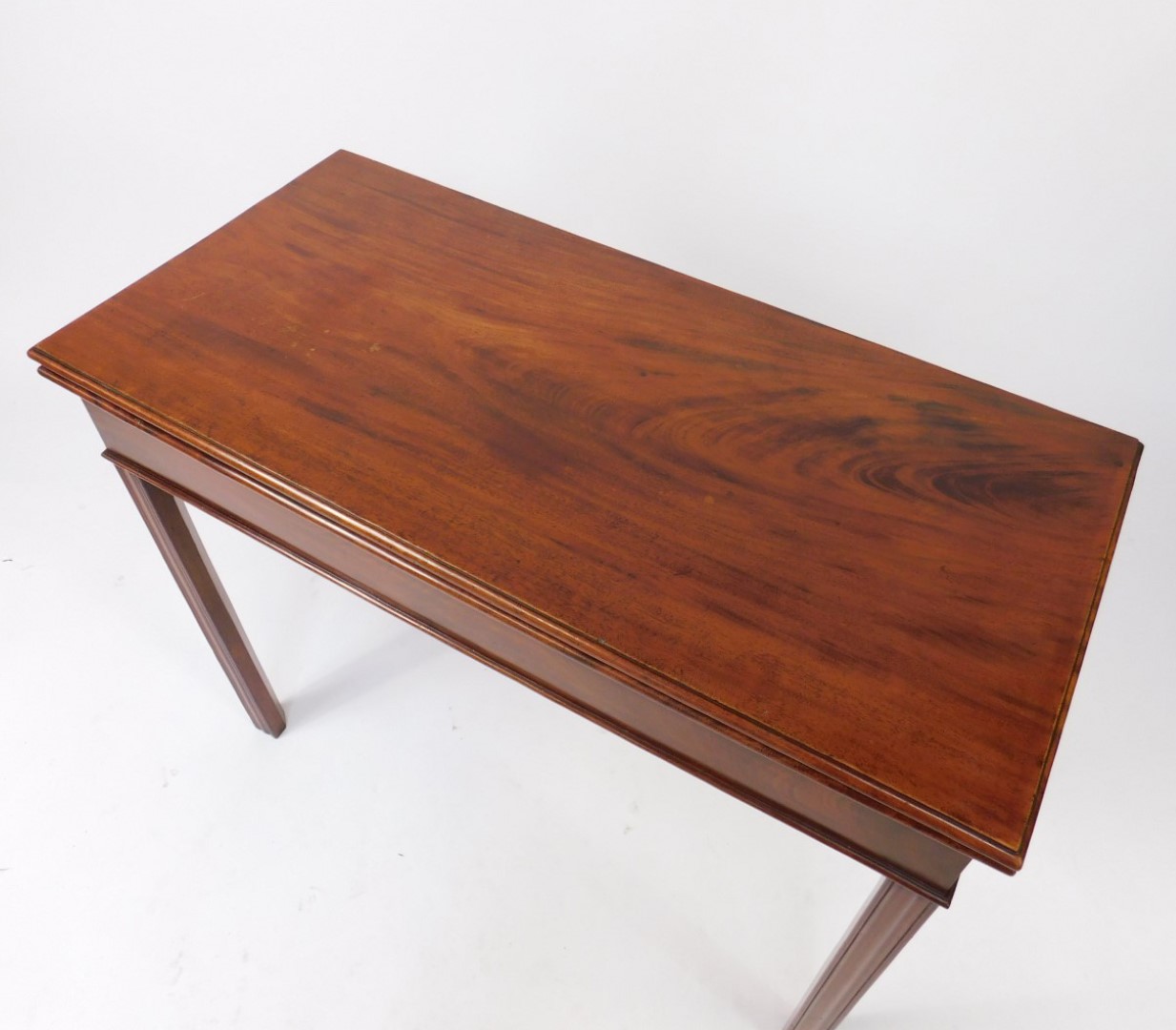 A George III mahogany fold over tea table, raised on fluted square legs, 73cm H, 92cm W, 42.5cm D. - Image 2 of 4