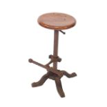 A Victorian cast iron machinist's stool, with an adjustable circular wooden seat, adjustable foot