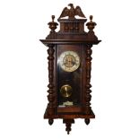 A German late 19thC walnut and oak Vienna wall clock, circular brass dial with enamel chapter ring