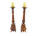 A pair of wooden altar candlesticks, with turned and carved foliate decoration, 62cm H (AF).