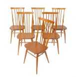 A set of six Ercol beech and elm stick back kitchen chairs, with solid seats, raised on turned