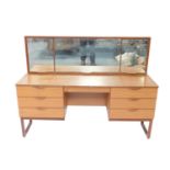 A Europa Furniture teak dressing table, with an adjustable triple mirror back, over one cushion