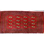 A small Turkish type rug, with a design of medals on a red ground, 105cm x 50cm.