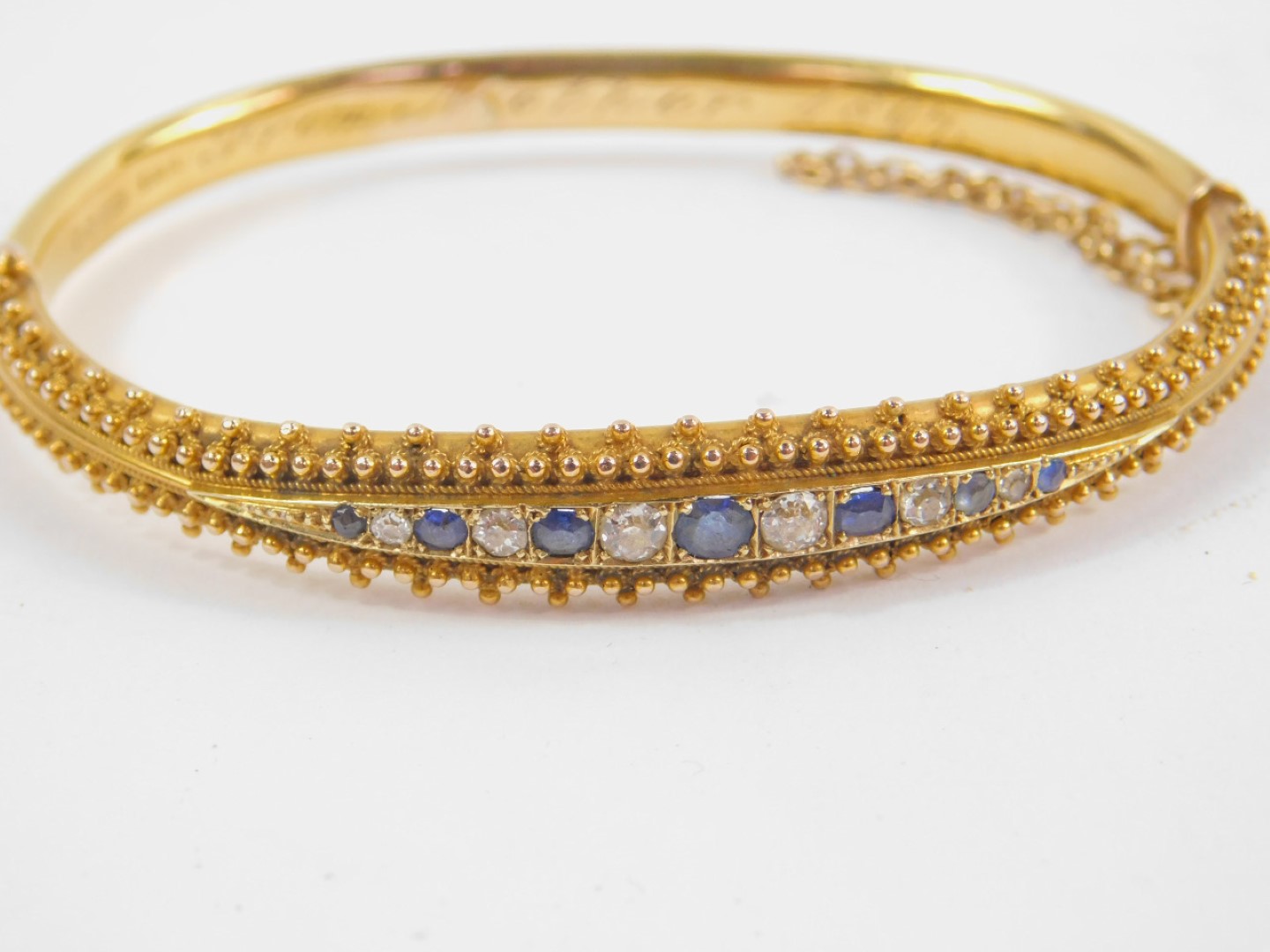 A Victorian 15ct gold sapphire and diamond bangle, channel set on a snap clasp with safety chain - Image 2 of 3