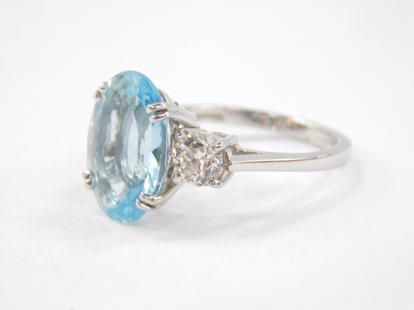 An 18ct white gold, aquamarine and diamond three stone ring, the oval cut aquamarine flanked by - Image 2 of 5