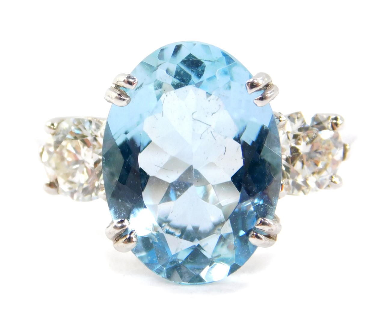 An 18ct white gold, aquamarine and diamond three stone ring, the oval cut aquamarine flanked by