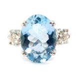 An 18ct white gold, aquamarine and diamond three stone ring, the oval cut aquamarine flanked by