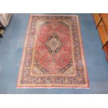 A Kashan rug, decorated with floral and foliate motifs, against a cream, blue and red ground,