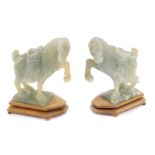 A pair of jadeite horses, 20thC, modelled with front leg raised, on a rectangular base, and wooden