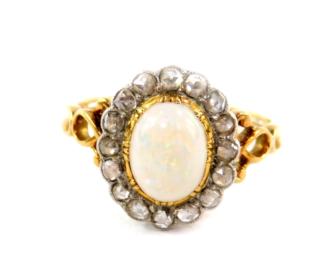 An opal and diamond ring, set in yellow metal, the cabachon opal set in a surround of sixteen old