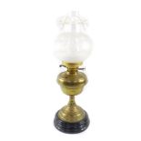 A Duplex early 20thC brass oil lamp, embossed with flowers, raised on a black ceramic socle, with