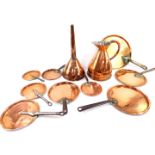 A 19thC copper funnel, half gallon jug, and eight copper graduated skillets with cast iron