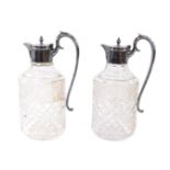 A pair of cut glass claret jugs with silver mounts, scroll handles and hinged lids, Garrard &
