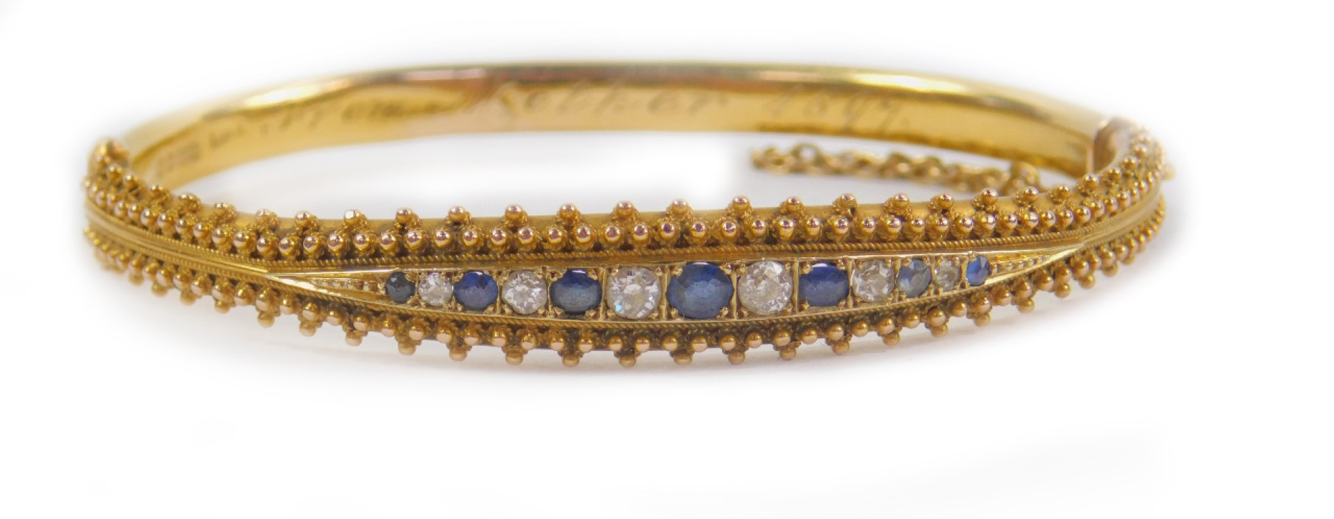 A Victorian 15ct gold sapphire and diamond bangle, channel set on a snap clasp with safety chain