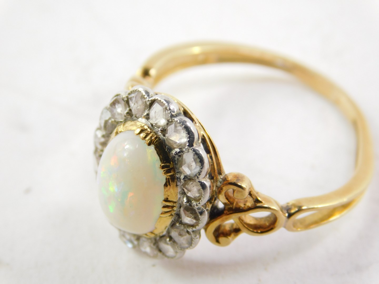 An opal and diamond ring, set in yellow metal, the cabachon opal set in a surround of sixteen old - Image 3 of 3