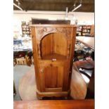 A modern pine corner wall cabinet, with single recess above a cupboard door, together with a bag