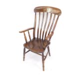 A Victorian oak and elm lath back kitchen chair, with turned arms and solid saddle seat, raised on