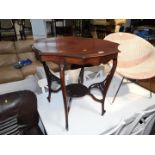 An Edwardian mahogany two tier occasional table, with fretwork stretchers and shaped legs.