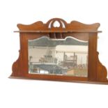 A Victorian Art Nouveau mahogany overmantel mirror, with a carved pediment and shelf, over a
