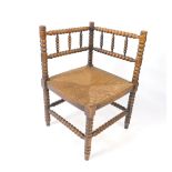 A Victorian bobbin turned corner chair, with a rush seat, the legs united by stretchers.