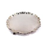 A silver pie crust circular salver, raised on four birds claw feet, Birmingham 1966, 23.97oz.