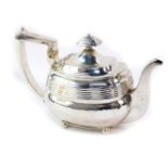 A George III silver teapot, of fluted ogee form, raised on four ball feet, makers mark indistinct,