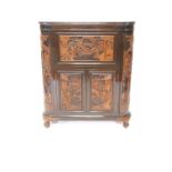 A 20thC Chinese hardwood bow front cocktail cabinet, deeply carved with panels of warriors, the