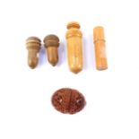 Four treen needle cases, together with a couquilla nut thimble case. (5)