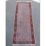 A Meshed runner, with an all over design within one wide and two narrow borders, 295cm x 107cm.