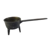 A Georgian bronze saucepan, with fluted handle, raised on tripod feet, 53cm L.