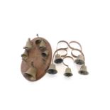 A set of five wall mounted servant's bells, together with an oval wall mounted part set of bells. (