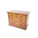 A Victorian mahogany and walnut chest of drawers, with two short over two long drawers, raised on