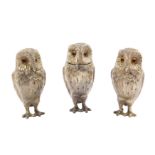A three piece silver novelty owl condiment set, each standing owl inset with glass eyes,