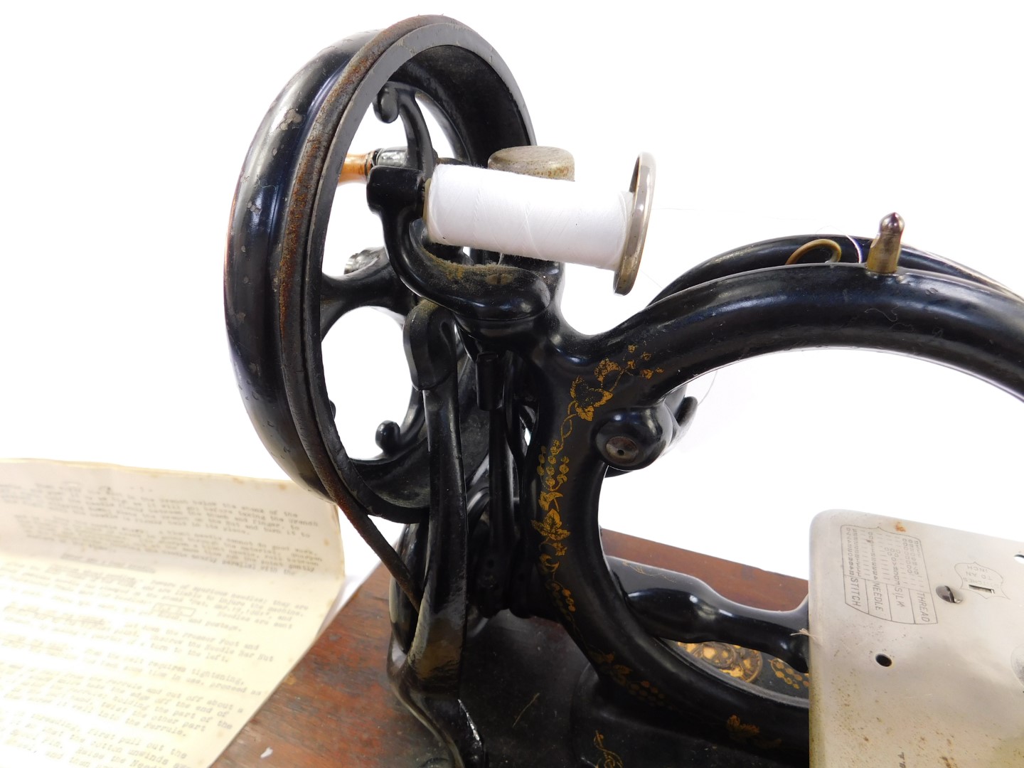 A late 19thC Wilcox & Gibbs sewing machine, gilt decorated black metal on a wooden base, together - Image 2 of 4