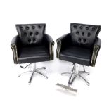 Two black leather barber's chairs, each with button back, raised on a metal frame and five point