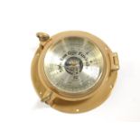 A Plastimo brass port hole barometer, circular cased, 22.5cm Dia.