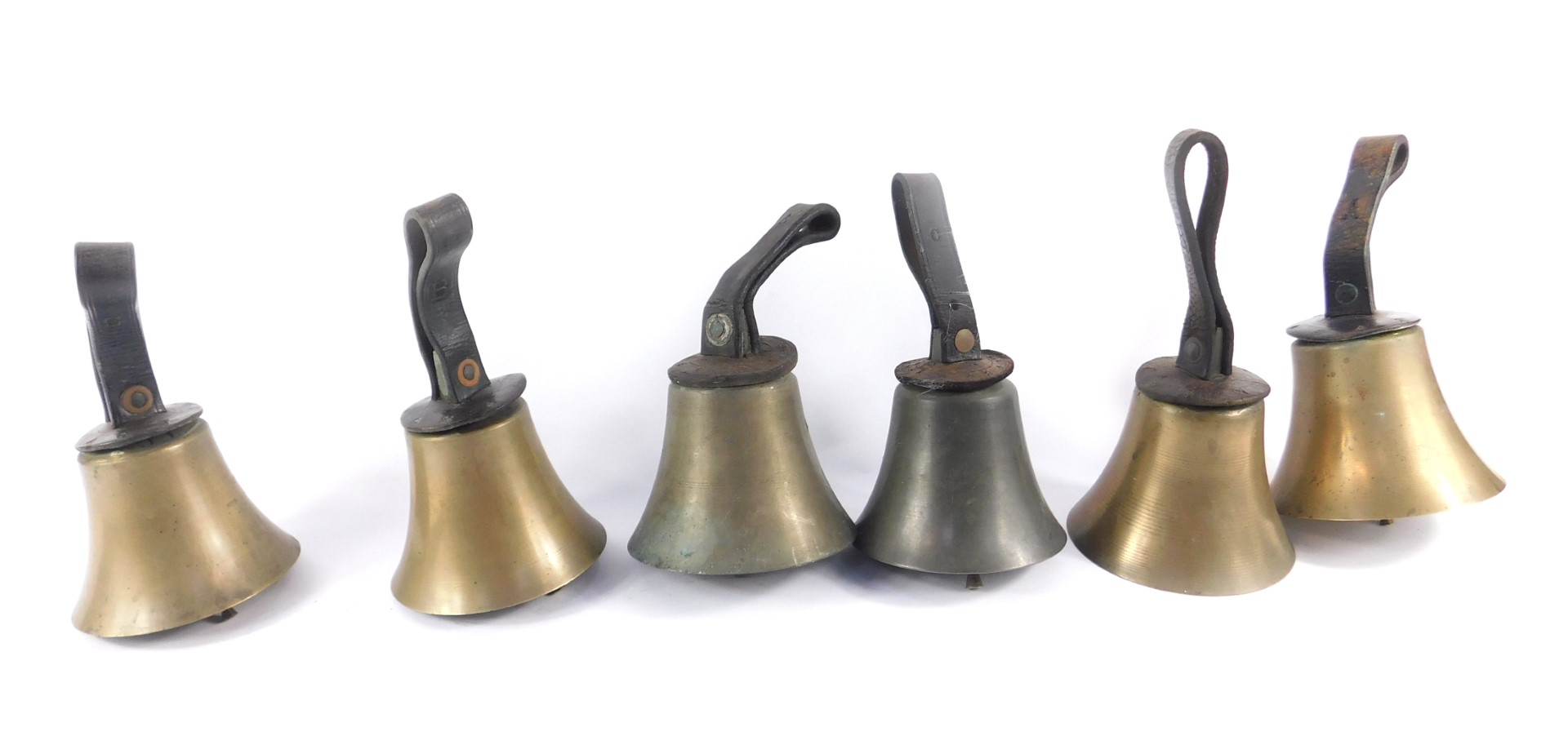 Six hand bells with hammers, one lacking, tooled leather handles.