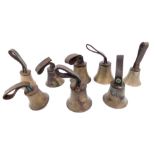 Eight hand bells, two bearing hammers, with leather handles inscribed with initials G S.