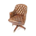 A mahogany and tan leather swivel armchair, with button back and button seated upholstery, raised on
