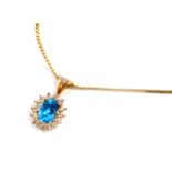 A topaz and diamond pendant, set in yellow metal, on a fancy link neck chain, on a bolt ring clasp